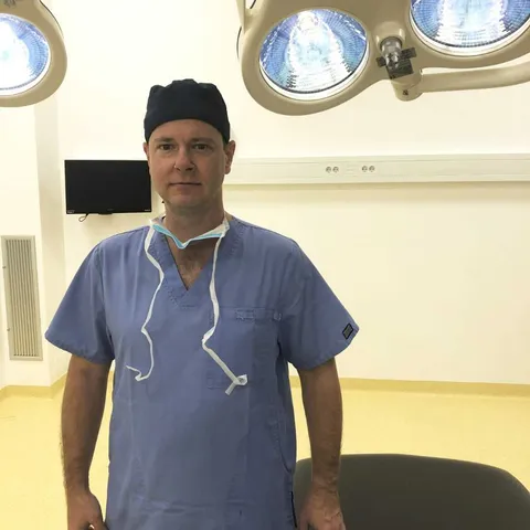Kirurg v modri delovni obleki v operacijski dvorani